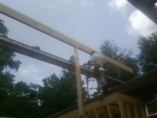 Carpenter setting a ridge beam over a new addition frame — Ice Dam Removal by Roofing Brothers in Francisco