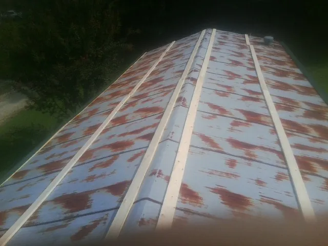 Rusted metal roof panels with new wood purlins before replacement — Storm Damage Roof Repair in Francisco by Roofing Brothers