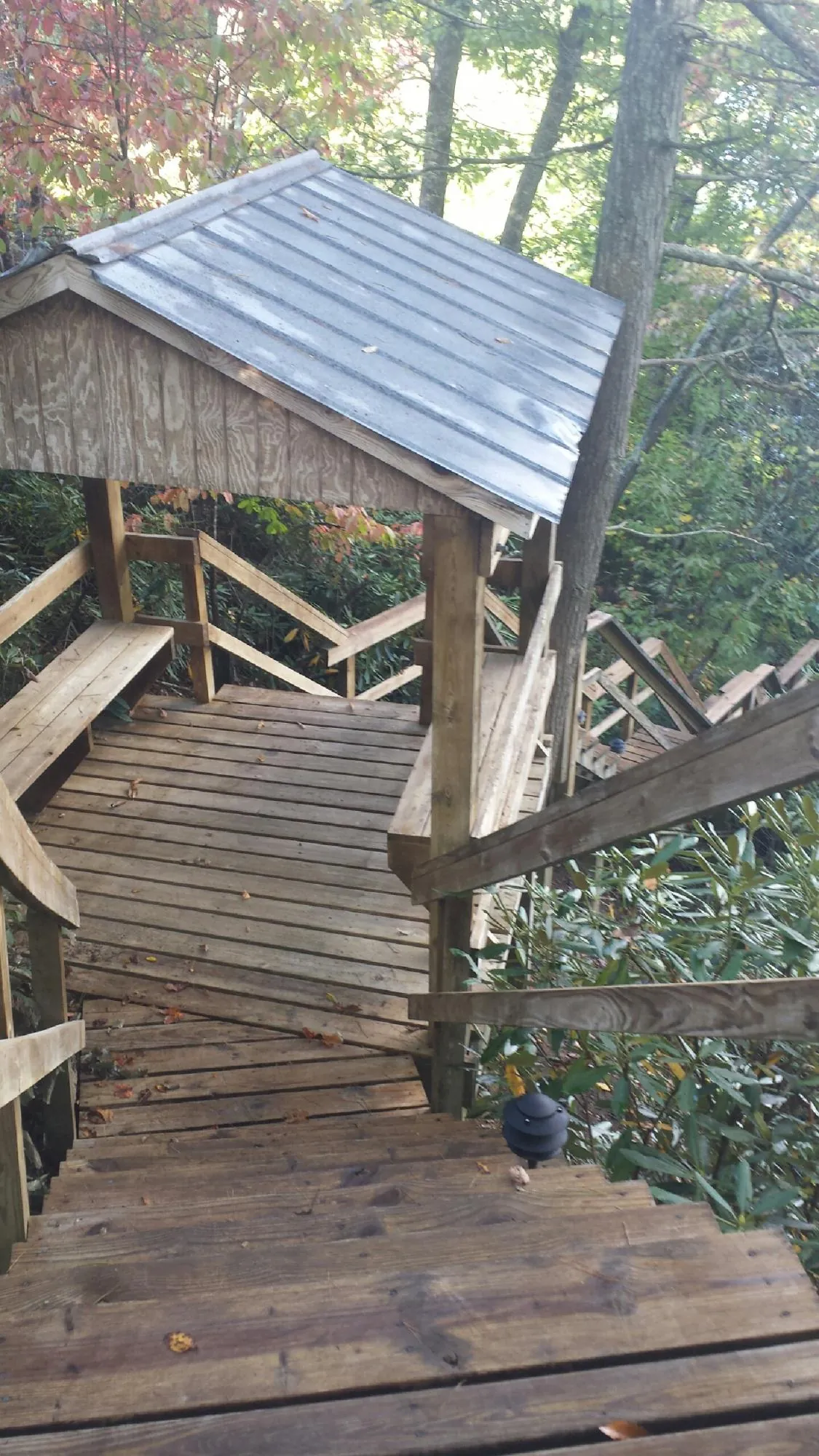 Metal roofed shelter over wooden steps on a wooded walkway — Skylight Repair & Installation work by our crew in Francisco