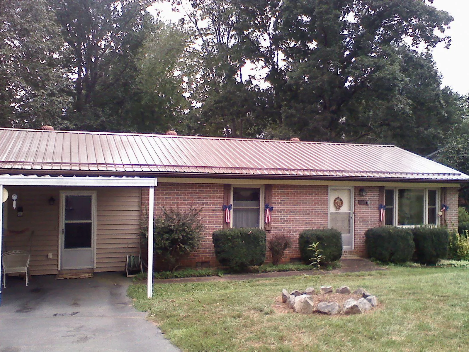 Bronze metal roof and carport on a brick ranch home — Roof Repair work by our crew in Francisco
